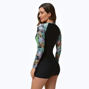 Detail view of long-sleeve surfing swimsuit with tropical leaf print and black panels