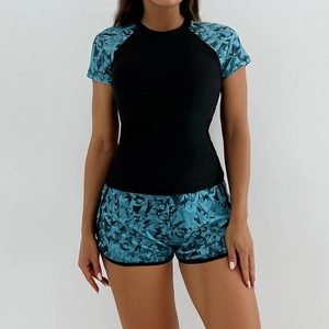 Detail of two-piece tankini set featuring floral sleeves and black athletic body