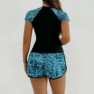 Rear view of women's two-piece tankini with short sleeves and geometric print shorts