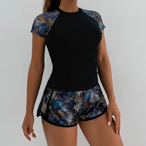 Detail view of two-piece tankini set featuring raglan sleeves and floral swim shorts