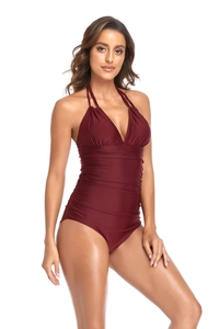 Detail view of burgundy one-piece swimsuit featuring halter V-neck and ruched waist design
