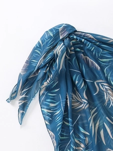 Détail du tissu en mesh bleu transparent avec motifs de feuilles de palmier pour maillots