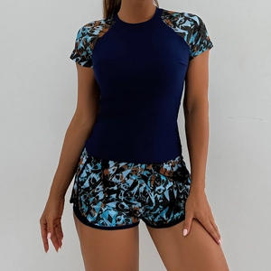 Detail of short sleeve athletic tankini swimsuit with blue torso and geometric print shorts
