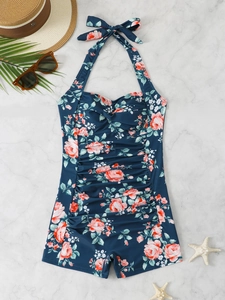 Detail of floral one-piece swimsuit with halter neck and slimming ruched tummy design
