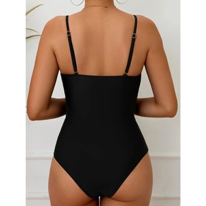 Detail of black one-piece swimsuit featuring adjustable thin straps and open back design