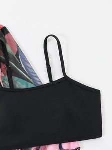 Detail of black bikini top featuring adjustable thin straps and tropical floral print