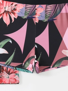Detail of tropical floral print bikini bottoms with pink hibiscus and palm leaf patterns