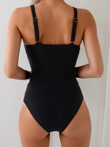 Detail view of black ribbed swimsuit showing adjustable thin straps with silver metal buckles