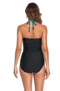 Detail view of backless one-piece swimsuit with blue palm leaf print halter straps