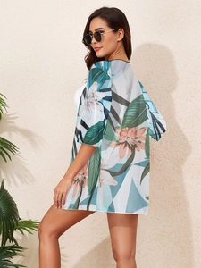 Detail of floral print chiffon beach cover-up with tropical green and orange patterns