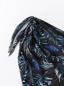 Détail d'un paréo noir transparent avec imprimé tropical bleu et fermeture à nouer