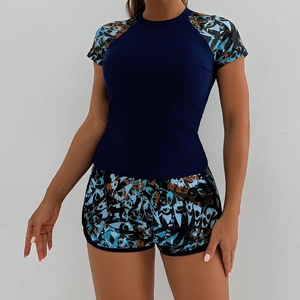 Women's two-piece tankini swimsuit with navy short sleeve top and patterned swim shorts