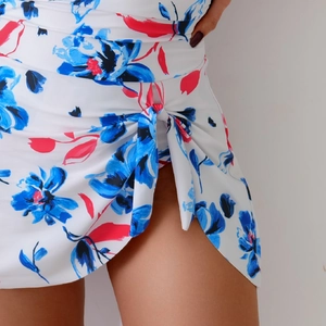 Close-up of floral print swimsuit detailing a stylish waist knot and pleated fabric