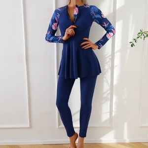 Detail of long-sleeve swimwear featuring a zipper neck and floral leaf pattern accents