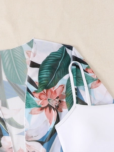Detail of white bikini top and tropical floral chiffon cover-up with leaf pattern