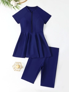 Detail of navy blue modest two-piece swimsuit with front zipper and pleated hem design