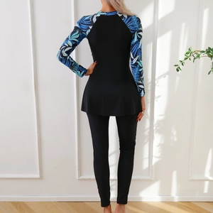 Back view of long-sleeve two-piece modest swimwear with tropical leaf print and black leggings