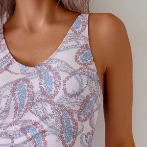Detail view of the deep V-neck and vintage paisley print on white one-piece swimwear