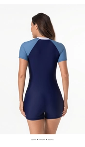 Back view of women's short-sleeve one-piece surfing swimsuit with navy blue color contrast