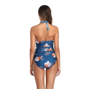 Detail view of floral halter swimsuit back with ruched fabric in navy and orange print