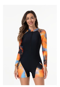 Close-up of front zipper and vibrant splash art print on long sleeve one-piece swimsuit