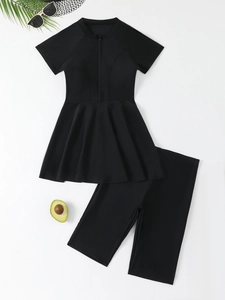 Detailed flat lay of black two-piece modest swimwear with zipper top and pleated hemline