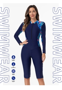 Close-up of long sleeve floral swimwear with front zipper and navy blue athletic fabric