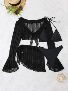 Flat lay of black four-piece bikini set with lace cover-up and summer beach accessories