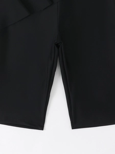 Detailed close-up of the stitching and elastic fabric on black swim shorts