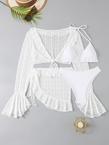 Flat lay of white lace beach cover-up with matching four-piece bikini and accessories
