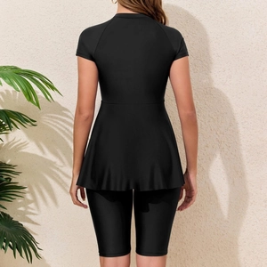 Two-piece black modest swimwear set featuring short sleeve peplum top and mid-length swim shorts