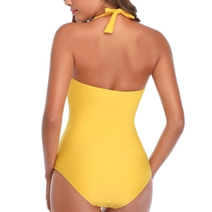 Detail of bright yellow one-piece swimsuit featuring halter neck and deep open back design