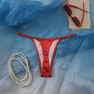 Makroaufnahme von rotem Hochglanz-String-Bikini mit elastischem Bund und Perlen