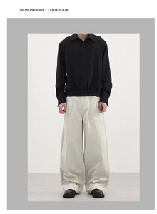 Détail de la veste noire pour homme à cordon et du pantalon cargo large beige décontracté