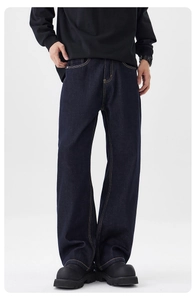 Détail d'un jean bleu brut ample avec surpiqûres jaunes et look streetwear moderne