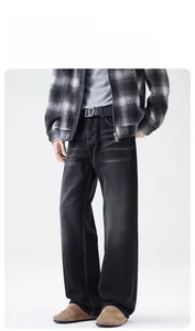 Gros plan du jean large gris anthracite montrant la texture délavée et les moustaches