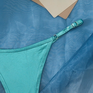Detailaufnahme des blauen Metallic-Bikinistoffs mit verstellbarem Riemen und Goldschnalle