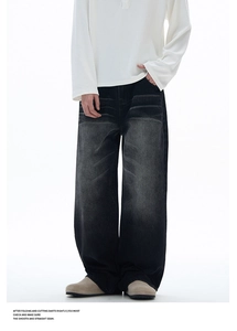 Detail shot of men's wide-leg jeans showing washed black denim and vintage distressed texture