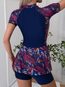 Women's two-piece modest short sleeve swimsuit with navy blue leaf print in back view