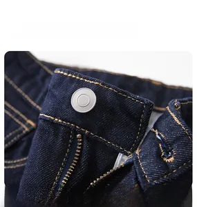 Macro de la taille d'un jean bleu foncé avec bouton en métal et surpiqûres jaunes