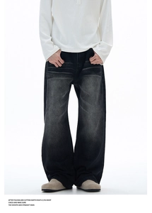 Detail showing the vintage washed ripple texture of high-street wide-leg black denim jeans