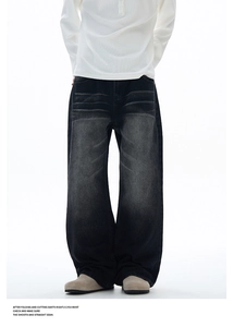 Detail of vintage washed black denim texture and whisker pattern on wide leg jeans