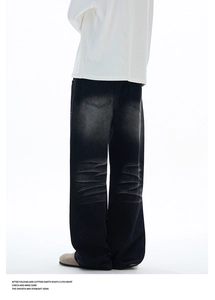 Detail of vintage washed black wide-leg jeans with high-waist straight fit and cat whiskers