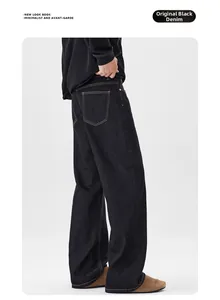 Vue arrière d'un jean noir en denim brut avec coutures contrastées orange et coupe large