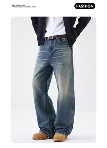 Dettaglio di jeans a gamba larga lavaggio vintage con baffature e texture retrò