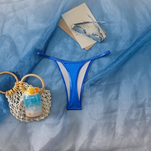 Detail der hoch taillierten elektrobauen Bikini-Tanga mit Metallic-Glanz