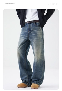 Dettaglio dei jeans blu vintage con lavaggio a baffo e vestibilità ampia a gamba larga