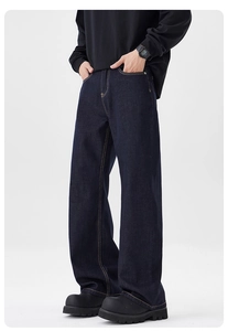 Détail d'un jean ample indigo foncé avec coutures jaunes contrastées et coupe large