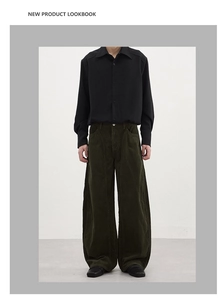 Detail of men's wide-leg corduroy trousers in olive green with relaxed fit and soft drape