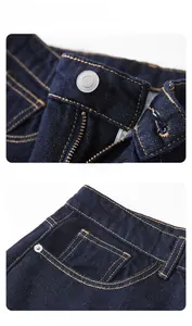 Détail macro d'un jean bleu foncé avec coutures cuivrées et bouton métallique